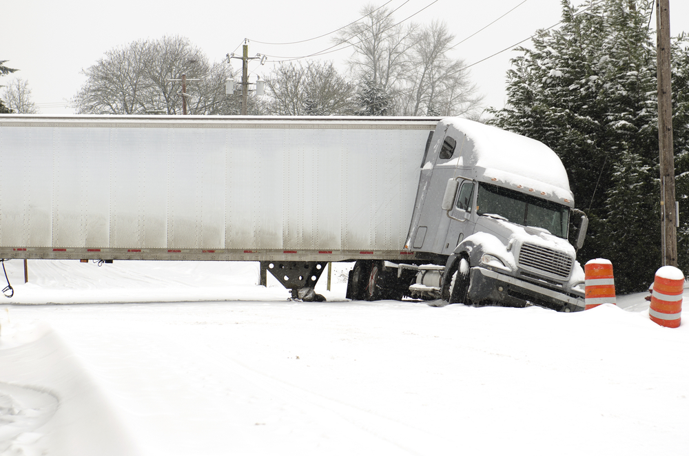 Semi truck jackknifed on interstate in snowy conditions